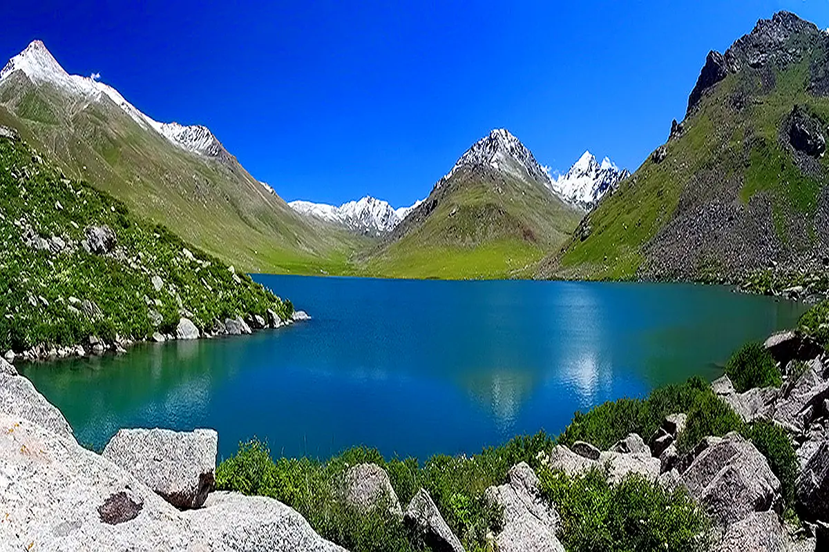 Lac Besh-Tash entre pentes rocheuses et sommets enneigés